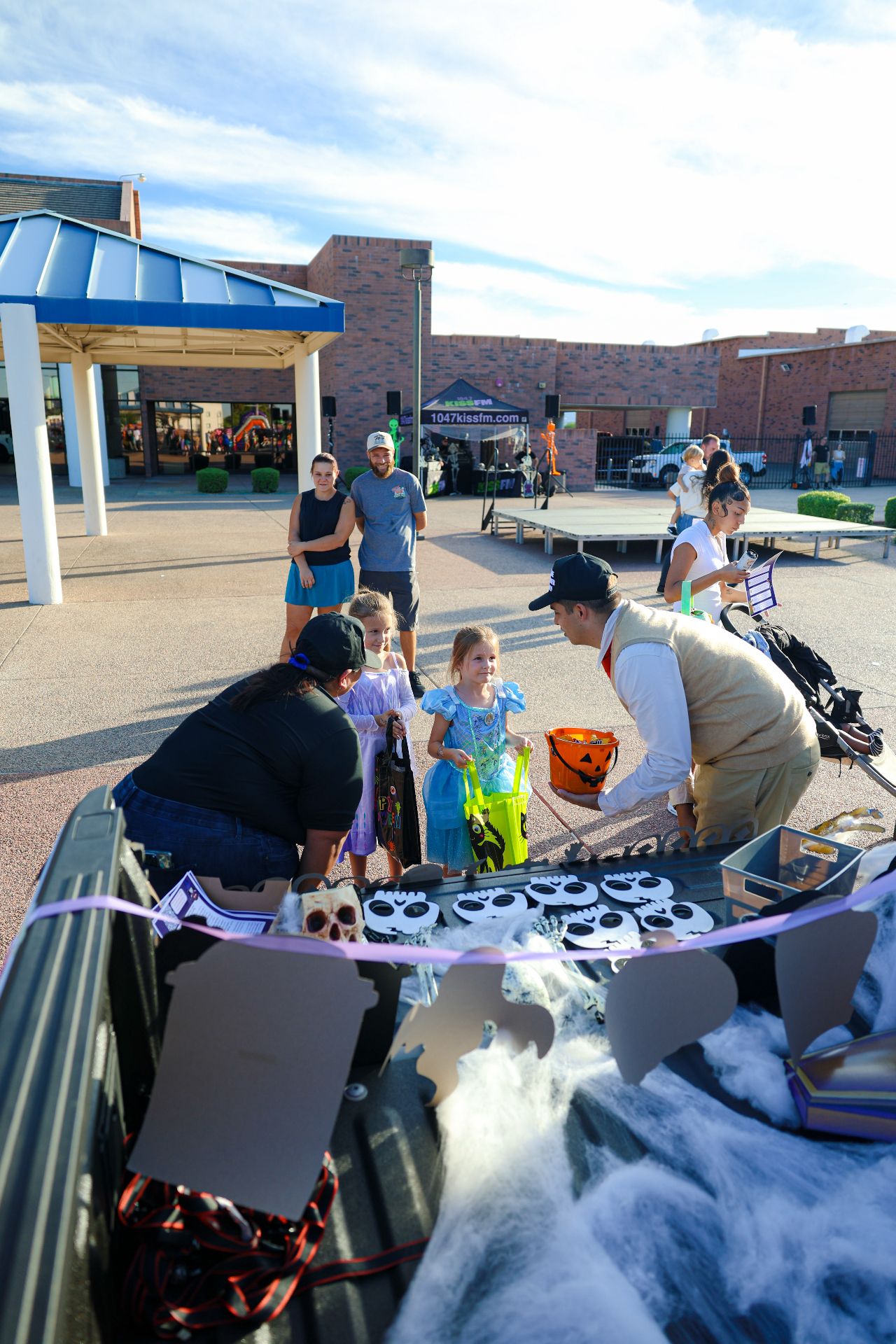 CARE volunteers handing out treats to kids in costumes from a decorated truck bed