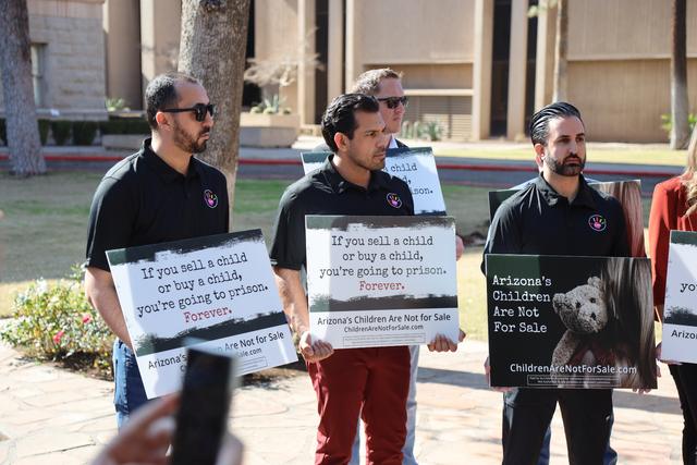 CARE advocates standing together holding signs against child trafficking