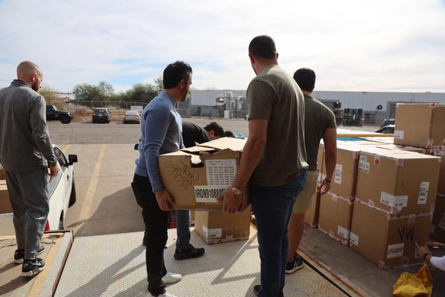 Volunteers carrying boxes of supplies across a parking lot