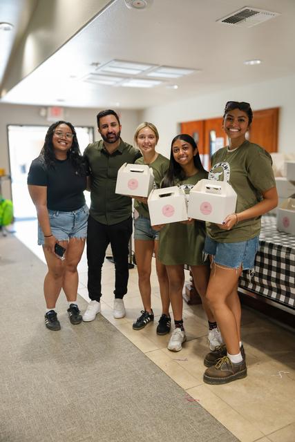 Volunteers holding boxed Thanksgiving meal kits
